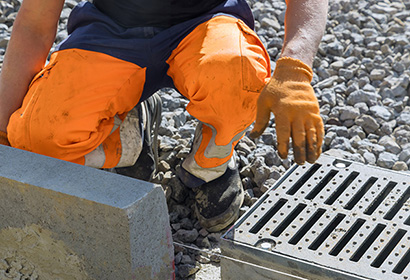 man inspecting storm drain